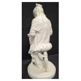 Sculpture of a woman sitting on a stool and reading a book