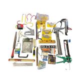 Assorted Hand Tools and Hardware Collection with Levels, Saws, Brackets, and Caulking Guns