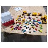 A SMALL COOLER FILLED WITH TOY CARS AND HEAVY EQUIPMENT RIGS A SMALL COOLER FILLED WITH TOY CARS AND HEAVY EQUIPMENT RIGS