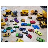 A SMALL COOLER FILLED WITH TOY CARS AND HEAVY EQUIPMENT RIGS A SMALL COOLER FILLED WITH TOY CARS AND HEAVY EQUIPMENT RIGS