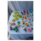 Mixed vintage Fisher-Price toys including vehicles, figures, and accessories