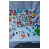 Mixed vintage Fisher-Price toys including vehicles, figures, and accessories
