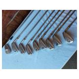 Golf equipment set including Johnny Miller Signature irons, wooden drivers, and a bag with assorted golf balls
