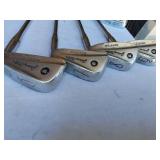 Golf equipment set including Johnny Miller Signature irons, wooden drivers, and a bag with assorted golf balls