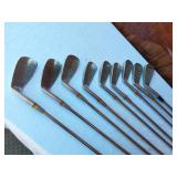 Golf equipment set including Johnny Miller Signature irons, wooden drivers, and a bag with assorted golf balls
