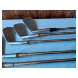 Golf equipment set including Johnny Miller Signature irons, wooden drivers, and a bag with assorted golf balls
