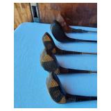 Golf equipment set including Johnny Miller Signature irons, wooden drivers, and a bag with assorted golf balls
