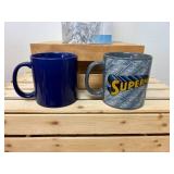 A themed Superman lot featuring two oversized mugs and a collectible 2016 Blue Line Superman figure in sealed packaging. A themed Superman lot featuring two oversized mugs and a collectible 2016 Blue Line Superman figure in sealed packaging.