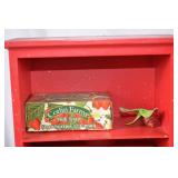 Vintage Red Painted Shelf with Strawberry-Themed Tins and Soap