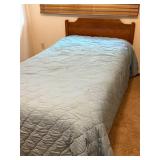 Twin Size Bed with Wooden Headboard and Light Blue Quilt