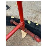 Red Metal Pipe Frame Clothing Stand and Roll of Perforated Metal