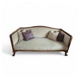 Antique Wood-Trimmed Sofa with Carved Paw Feet and Accent Pillows