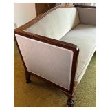 Antique Wood-Trimmed Sofa with Carved Paw Feet and Accent Pillows