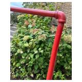 Red Metal Pipe Frame Clothing Stand and Roll of Perforated Metal