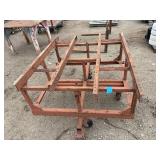 Heavy-duty industrial rolling cart probably designed for transporting pipes or beams 62 ¾” l x 48” w x 33”