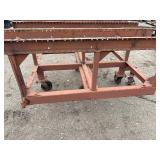 Heavy-duty industrial rolling cart probably designed for transporting pipes or beams 62 ¾” l x 48” w x 33”
