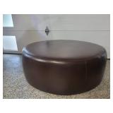 A Modern Round Brown Leather Coffee Table / Ottoman by Room and Board.