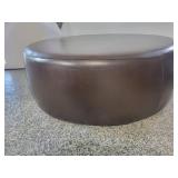 A Modern Round Brown Leather Coffee Table / Ottoman by Room and Board.