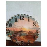 A signed hand-painted saw blade by M. Cadlen 2002 and a hand-painted scenery wood cut out saw blade clock