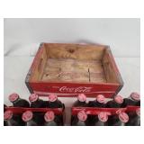 Collection of Vintage Coca-Cola Bottles with Holiday Labels and Wooden Crate