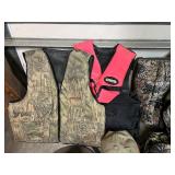 Assorted Hunting Gear Collection with Vests, Caps, Camo Jacket, and Carry Bags