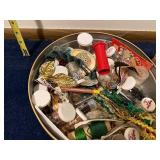 Assorted Craft Supplies and Decorative Items in Tin