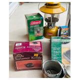 LR - Vintage Camp Cookware Collection with Cast Iron, Percolator, Lantern, and Steamer Kettle