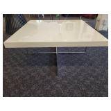 A  white cocktail/coffee table with chrome legs by A.L.F. Italy.