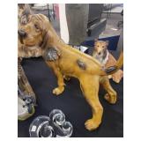 A table full of decor items, animal figures, pottery, glassware, bookends, candle holders, dolls etc.