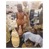 A table full of decor items, animal figures, pottery, glassware, bookends, candle holders, dolls etc.