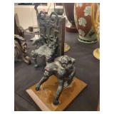 A table full of decor items, animal figures, pottery, glassware, bookends, candle holders, dolls etc.