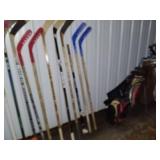 Sports Equipment Lot: Hockey Sticks, Golf Bags with Clubs, and Water Bottle Carrier