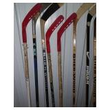 Sports Equipment Lot: Hockey Sticks, Golf Bags with Clubs, and Water Bottle Carrier