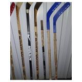 Sports Equipment Lot: Hockey Sticks, Golf Bags with Clubs, and Water Bottle Carrier