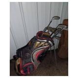 Sports Equipment Lot: Hockey Sticks, Golf Bags with Clubs, and Water Bottle Carrier