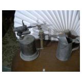 vintage gasoline blowtorch and a metal oil can or filler.
