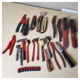 Assorted hand tools including Craftsman ratchet, wire strippers, utility knives, brushes, and sockets