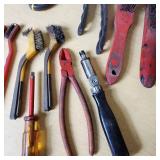 Assorted hand tools including Craftsman ratchet, wire strippers, utility knives, brushes, and sockets