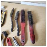 Assorted hand tools including Craftsman ratchet, wire strippers, utility knives, brushes, and sockets