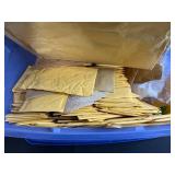 Collection of Padded Mailing Envelopes and Bubble Mailers in Storage Bin