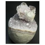 A stunning Amethyst crystal perched on its natural matrix, featuring delicate Calcite inclusions that add depth and character.