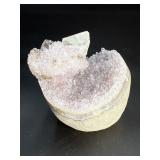 A stunning Amethyst crystal perched on its natural matrix, featuring delicate Calcite inclusions that add depth and character.