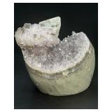 A stunning Amethyst crystal perched on its natural matrix, featuring delicate Calcite inclusions that add depth and character.