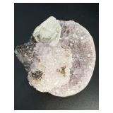 A stunning Amethyst crystal perched on its natural matrix, featuring delicate Calcite inclusions that add depth and character.