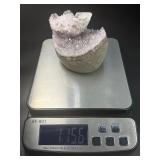 A stunning Amethyst crystal perched on its natural matrix, featuring delicate Calcite inclusions that add depth and character.