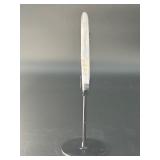 A luminous Botswana Agate druzy carved into a moon shape, showcasing delicate bands of soft gray, caramel, and cream. The sparkling druzy surface catches the light, in a custom metal stand.