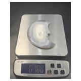 A luminous Botswana Agate druzy carved into a moon shape, showcasing delicate bands of soft gray, caramel, and cream. The sparkling druzy surface catches the light, in a custom metal stand.