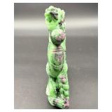A striking hand-carved dragon sculpted from natural ruby zoisite, showcasing vibrant green and deep red tones.