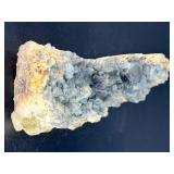 A striking specimen of large blue fluorite perched atop a clear quartz crystal matrix.