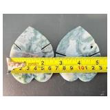 A serene moss agate collection featuring two hand-carved leaf-shaped pieces and a polished sphere with a druzy center resting on a lotus stand.